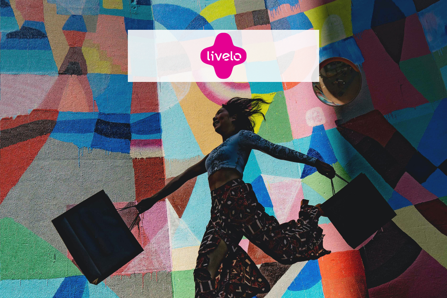 Mulher feliz pulando com suas bolsas de compra com Logo Livelo