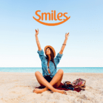 mulher branca feliz em uma praia com logo da Smiles