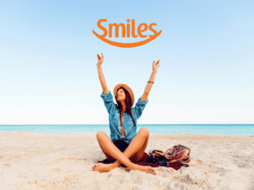 mulher branca feliz em uma praia com logo da Smiles