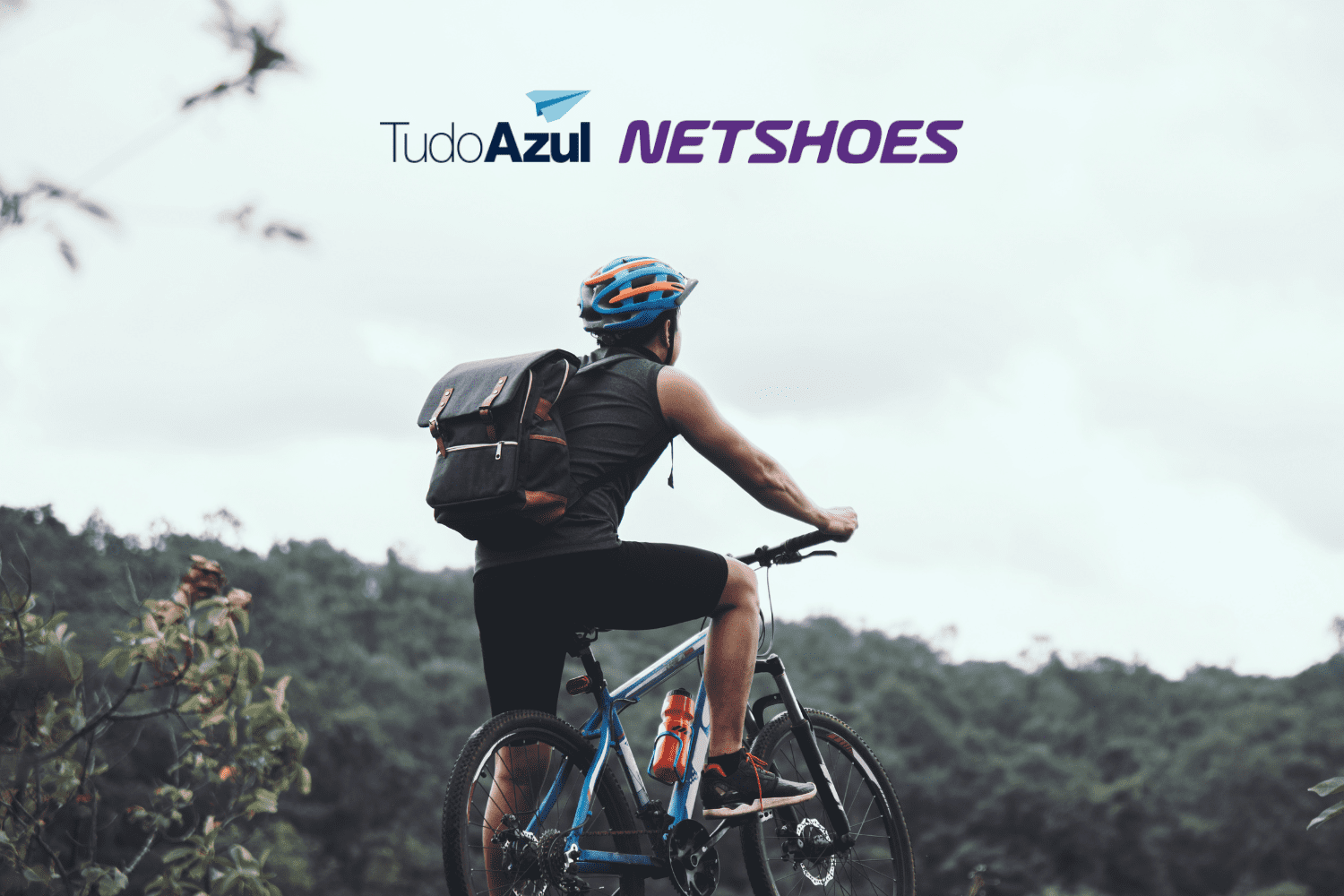 homem de bicicleta vendo o horizonte com logo tudoazul e netshoes