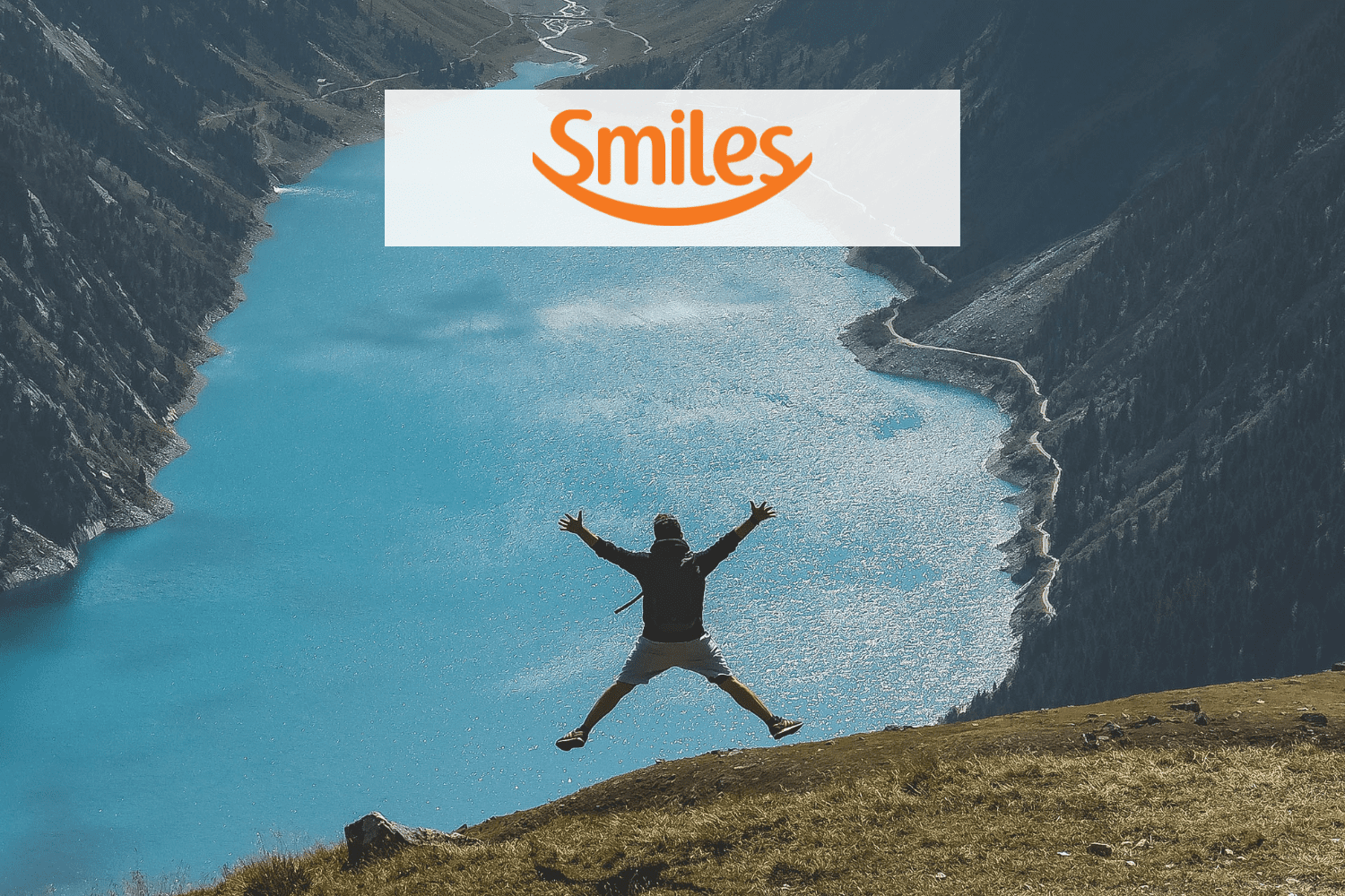 pessoa pulando olhando o horizonte com a logo Smiles