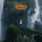mulher branca em frente a uma cachoeira com logo Smiles