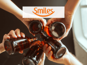 pessoas brindando garrafas com logo Smiles
