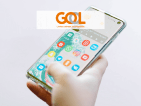 mão segurando um celular mexendo em aplicativos com logo Gol