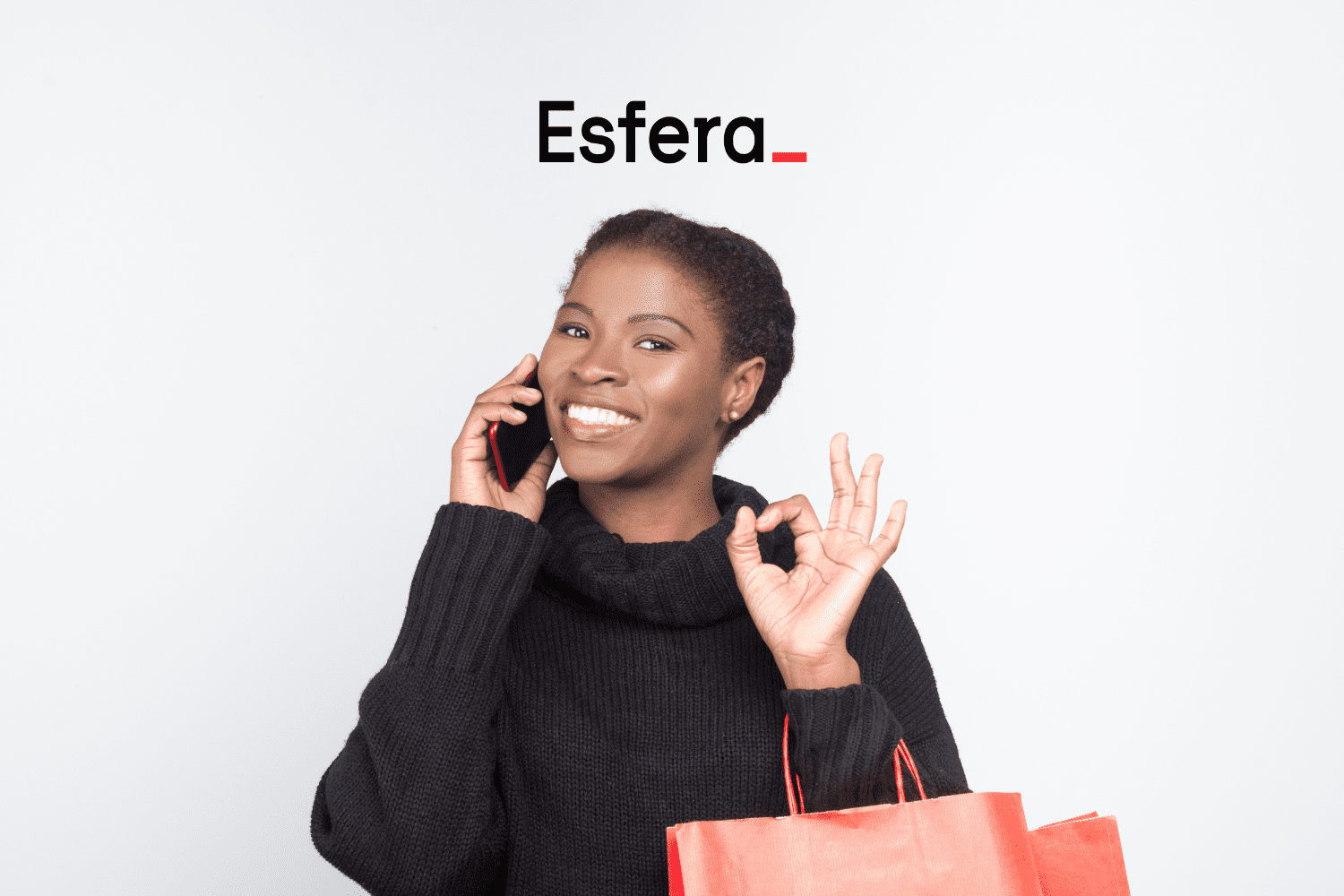 mulher preta sorrindo no telefone e com sacola de compra com logo Esfera