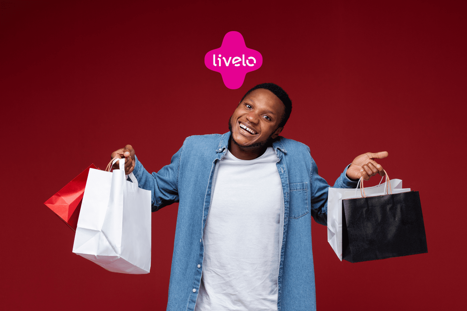 homem preto sorrindo com sacolas de compra e logo Livelo