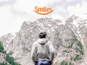 homem olhando montanhas com logo Smiles