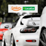 Carro branco com logo Smiles e Localiza