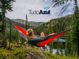 mulher loira deitada em uma rede olhando o horizonte com logo TudoAzul