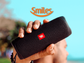 homem segurando uma caixa de som com logo Smiles