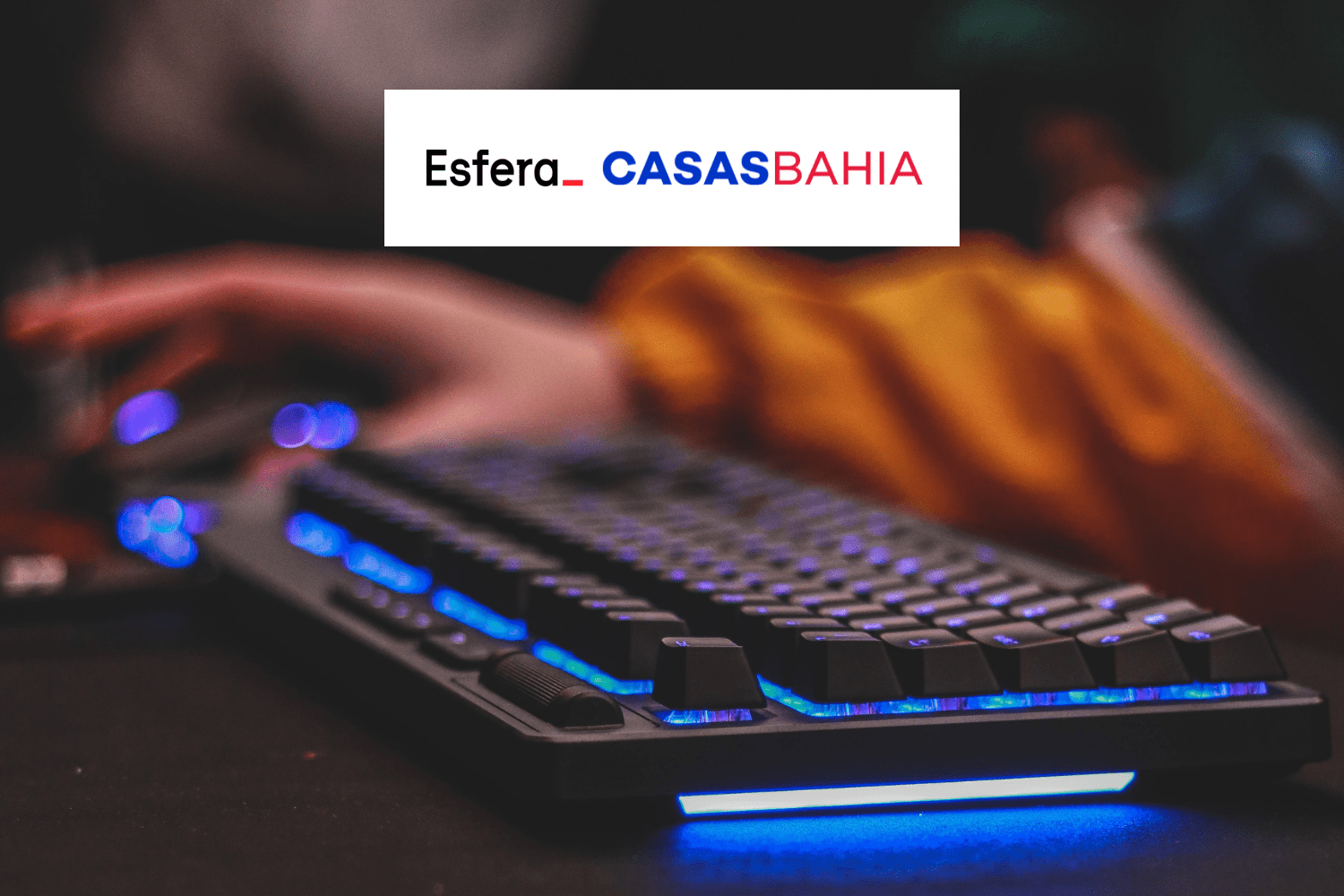 teclado de computador luminoso com logo Esfera e Casas Bahia