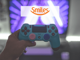 pessoa segurando controle de video game com logo Smiles