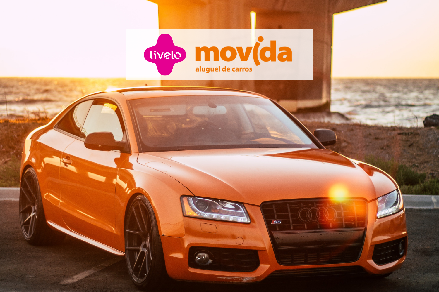 Carro laranja com logo Livelo e Movida
