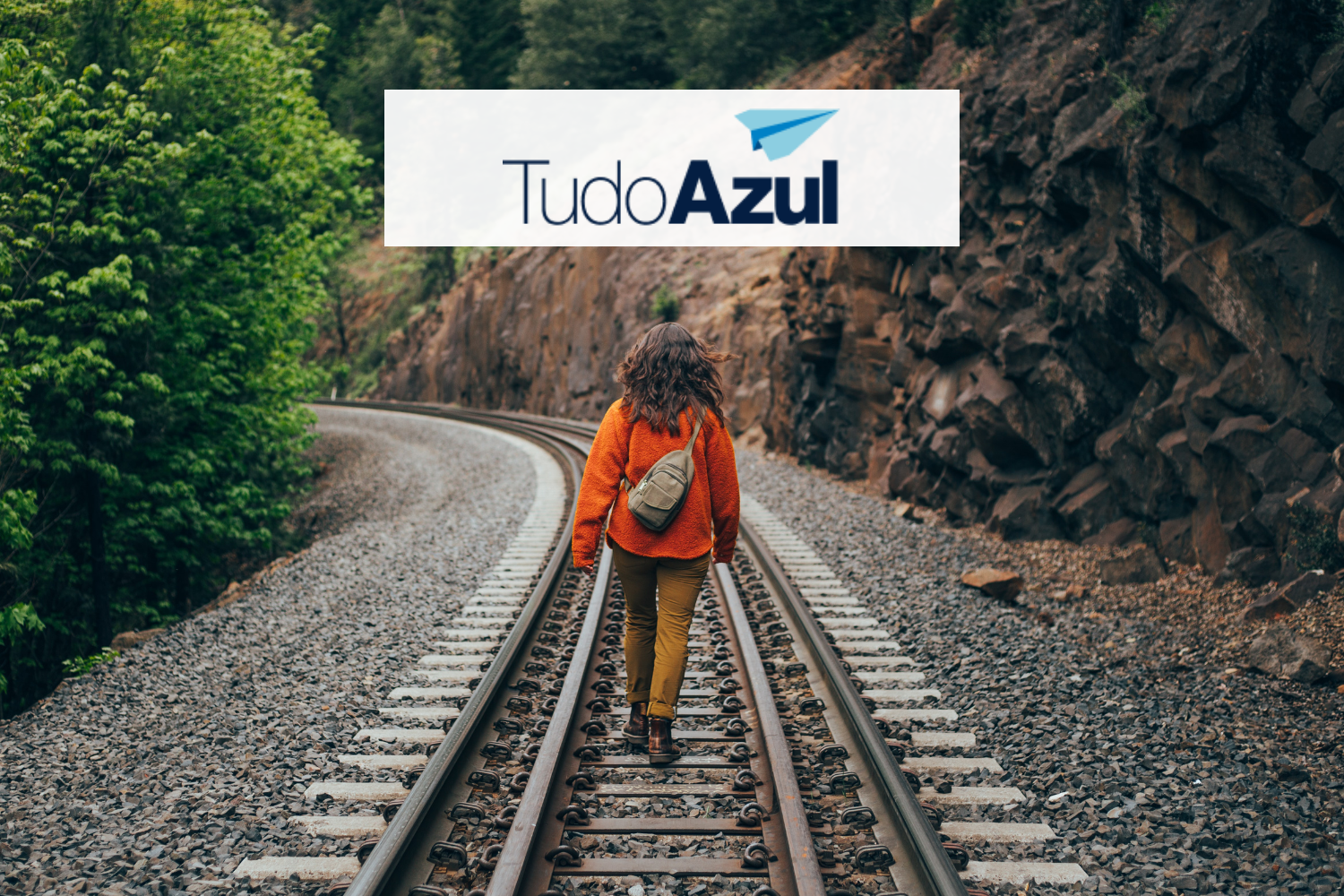mulher andando em uma linha de trem com logo TudoAzul