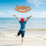 Criança pulando olhando a praia com logo Smiles