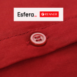 botão de uma roupa vermelha com logo Esfera e Renner