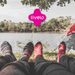 visão deitada de pés com meias e um cenário de camping com logo Livelo