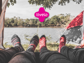 visão deitada de pés com meias e um cenário de camping com logo Livelo