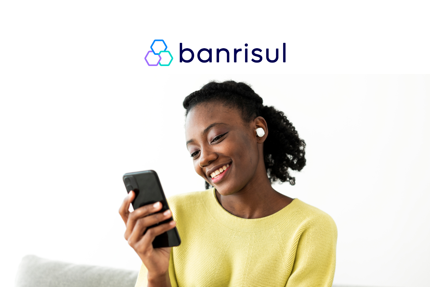mulher negra utilizando o celular com logo Banrisul