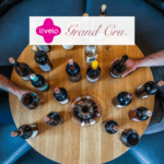 taças de vinho em uma mesa com logo Livelo e Grand Cru