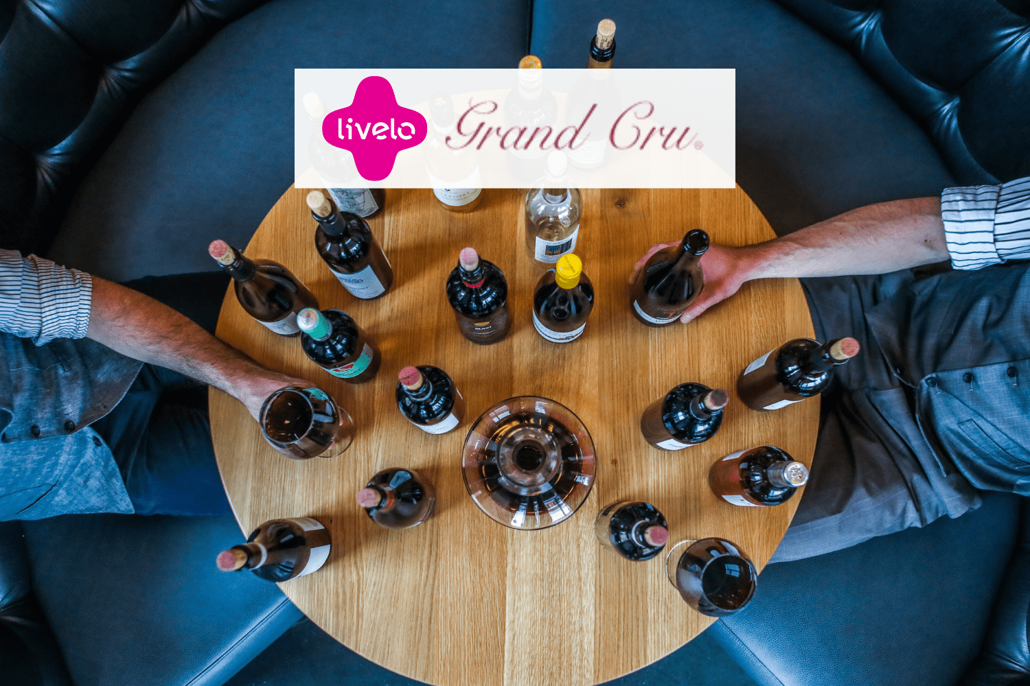 taças de vinho em uma mesa com logo Livelo e Grand Cru