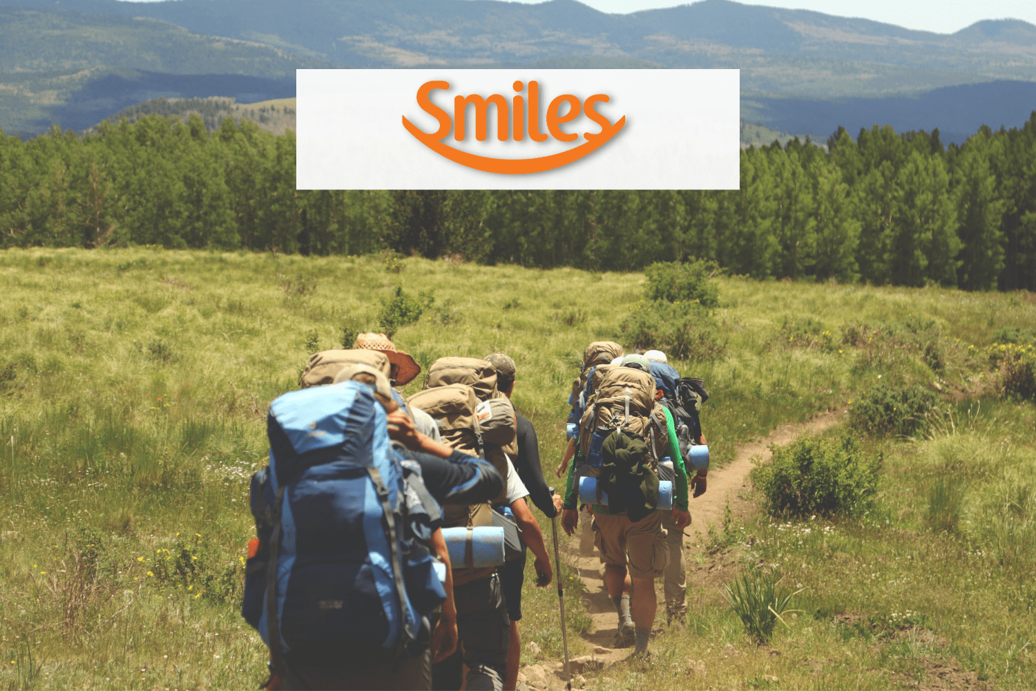 grupo de amigos com mochila de viagem fazendo uma trilha com logo Smiles