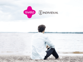 Homem com camisa branca e calça olhando para a praia com logo Livelo e Individual 10 pontos Livelo