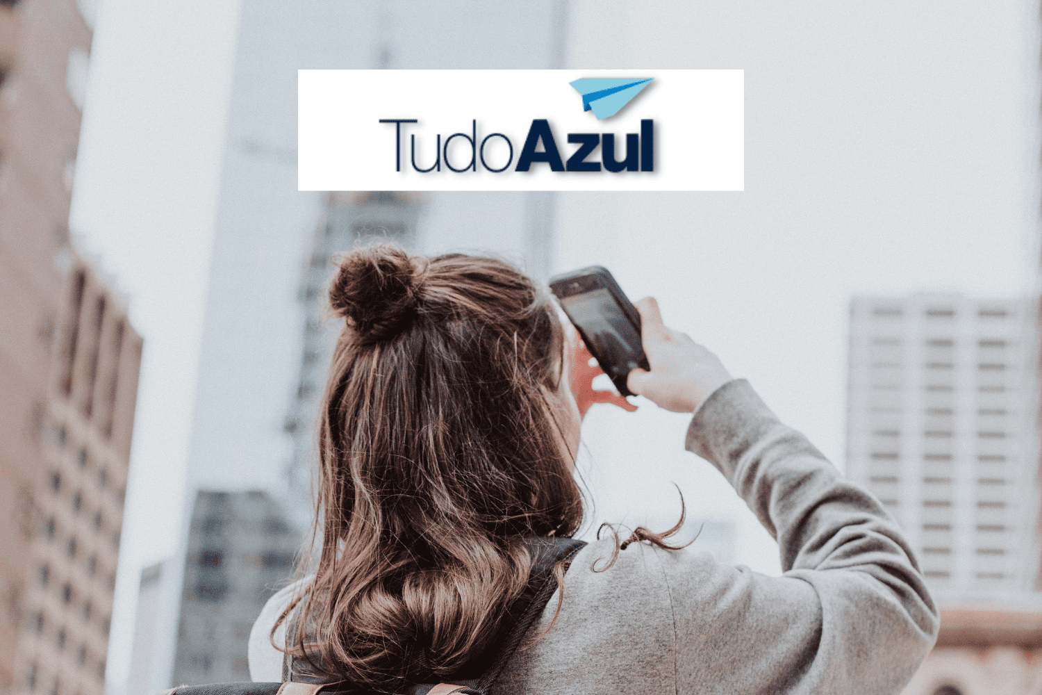 mulher tirando foto com celular e logo TudoAzul Upgrade no Clube TudoAzul