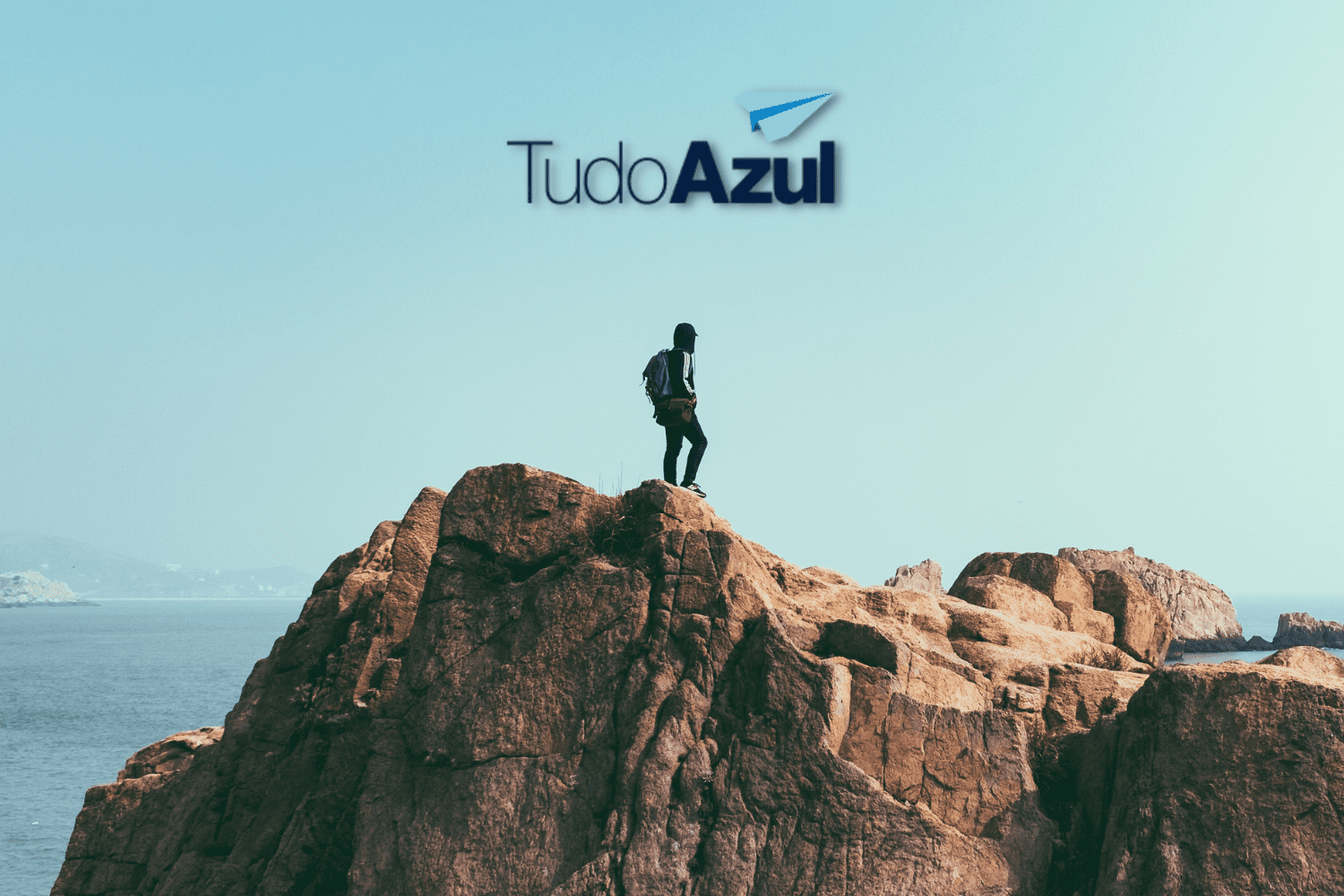 Pessoa no topo de uma montanha com logo TudoAzul pontos TudoAzul