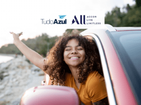 mulher preta sorridente na janela do carro com logo TudoAzul e ALL