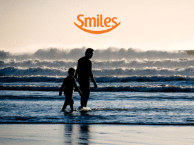 pai e filho em frente ao mar com logo Smiles Clube Smiles