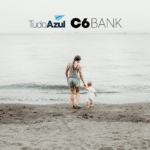 mulher com criança pequena indo em direção ao mar com logo TudoAzul e C6 Bank bônus TudoAzul