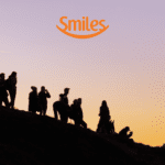 silhueta de amigos olhando a vista com logo Smiles Clube Smiles