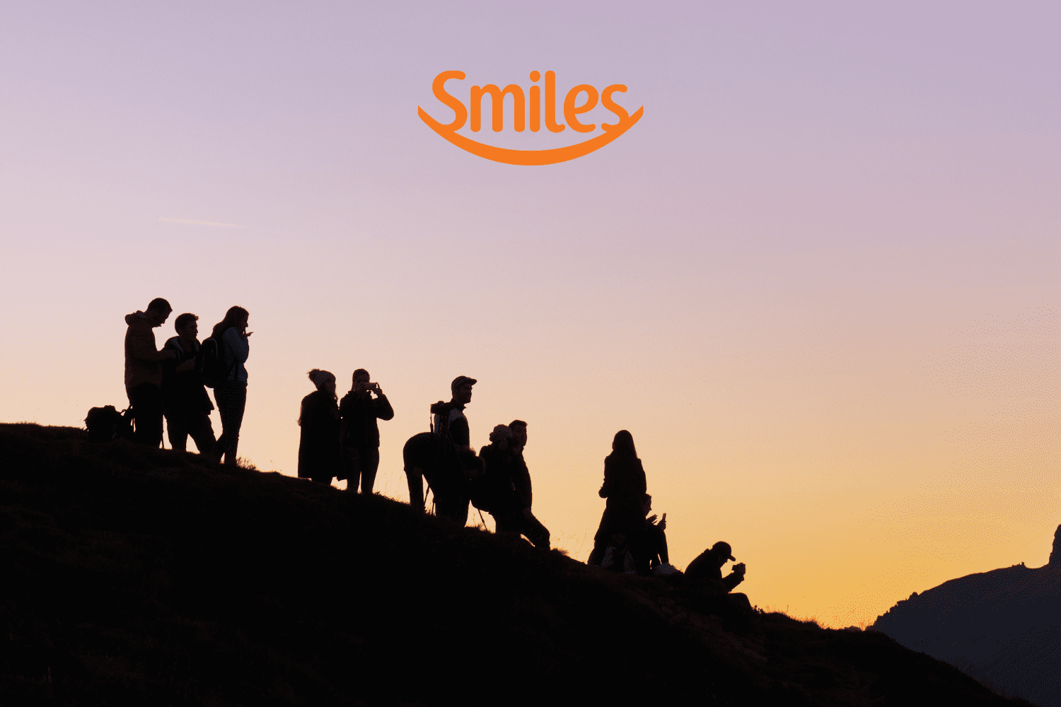 silhueta de amigos olhando a vista com logo Smiles Clube Smiles