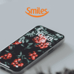 iphone em uma mesa com logo Smiles Pontos Smiles