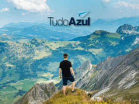 homem branco no topo de uma montanha com logo TudoAzul Clube TudoAzul