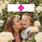 mãe beijando filha em um jardim feliz com logo Livelo Shopping Livelo