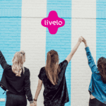três amigas na frente de uma parede azul com logo Livelo Clube Livelo Day