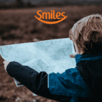 criança olhando um mapa com logo Smiles Clube Smiles