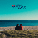 casal sentado olhando a praia Bônus Latam Pass