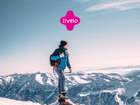 homem na neve olhando para o horizonte com logo Livelo Clube Livelo