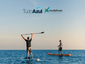 dois homens praticando stand up paddle no mar, com logo TudoAzul e Modalmais. bônus TudoAzul