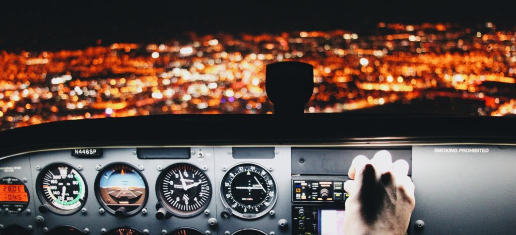 pessoa mexendo em uns botões de uma aeronave  Licença de piloto de linha aérea (PLA) no curso de piloto de avião