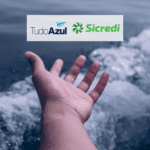 mão estendida para o mar com logo TudoAzul e Sicredi bônus TudoAzul