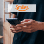 pessoa mexendo em um celular samsung com logo Smiles pontos Smiles