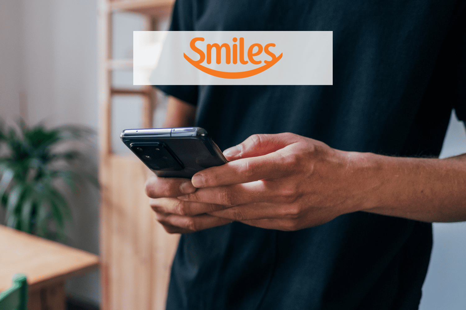pessoa mexendo em um celular samsung com logo Smiles pontos Smiles