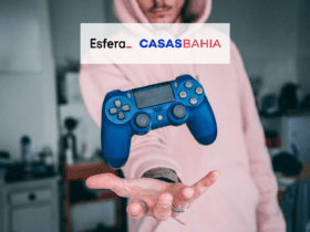 Pessoa jogando um controle de vídeo game com logo Esfera e Casas Bahia 10 pontos Esfera