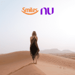 mulher loira no deserto com logo Smiles e Nubank bônus Smiles
