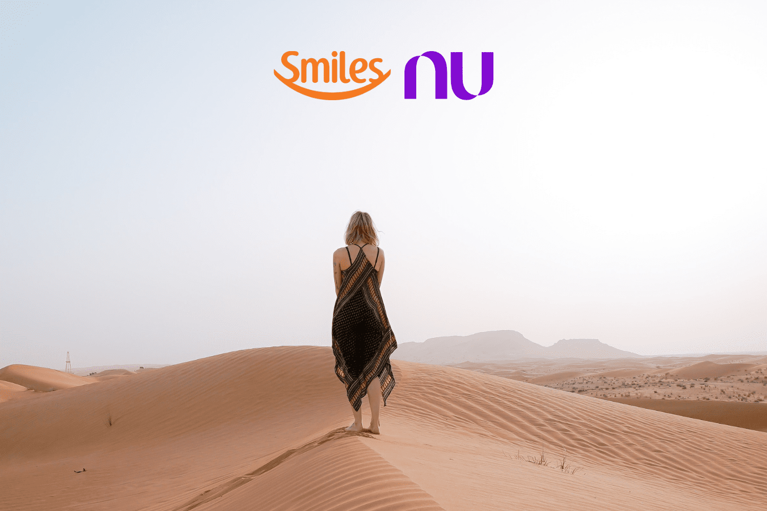 mulher loira no deserto com logo Smiles e Nubank bônus Smiles
