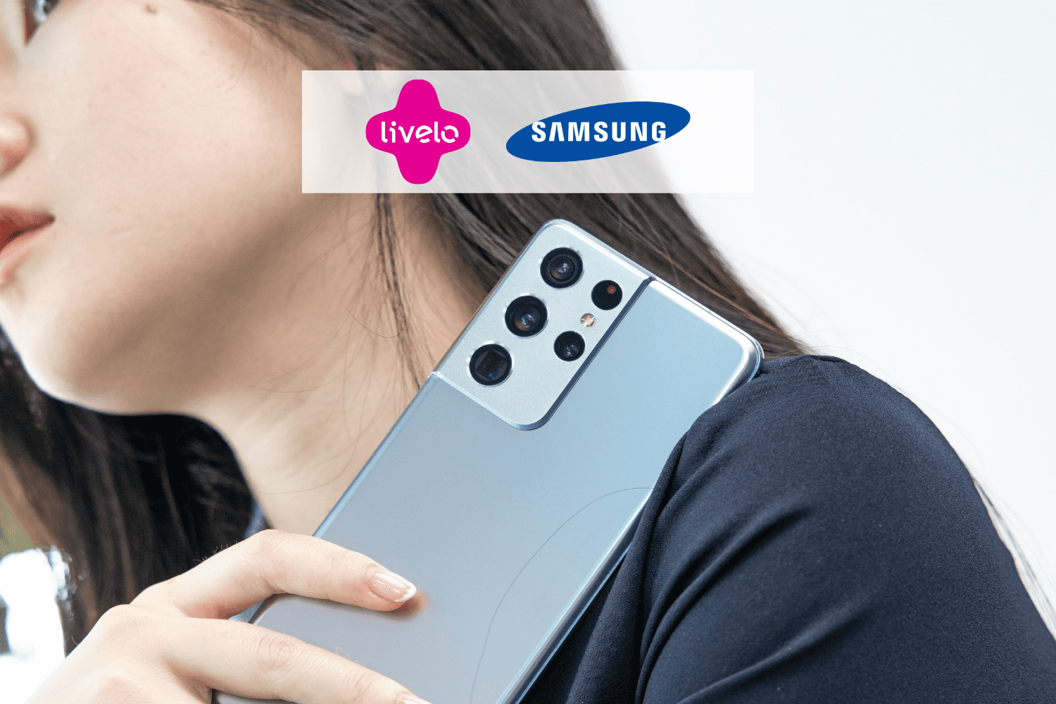 mulher asiática segurando um celular no ombro, com logo Livelo e Samsung 10 pontos Livelo